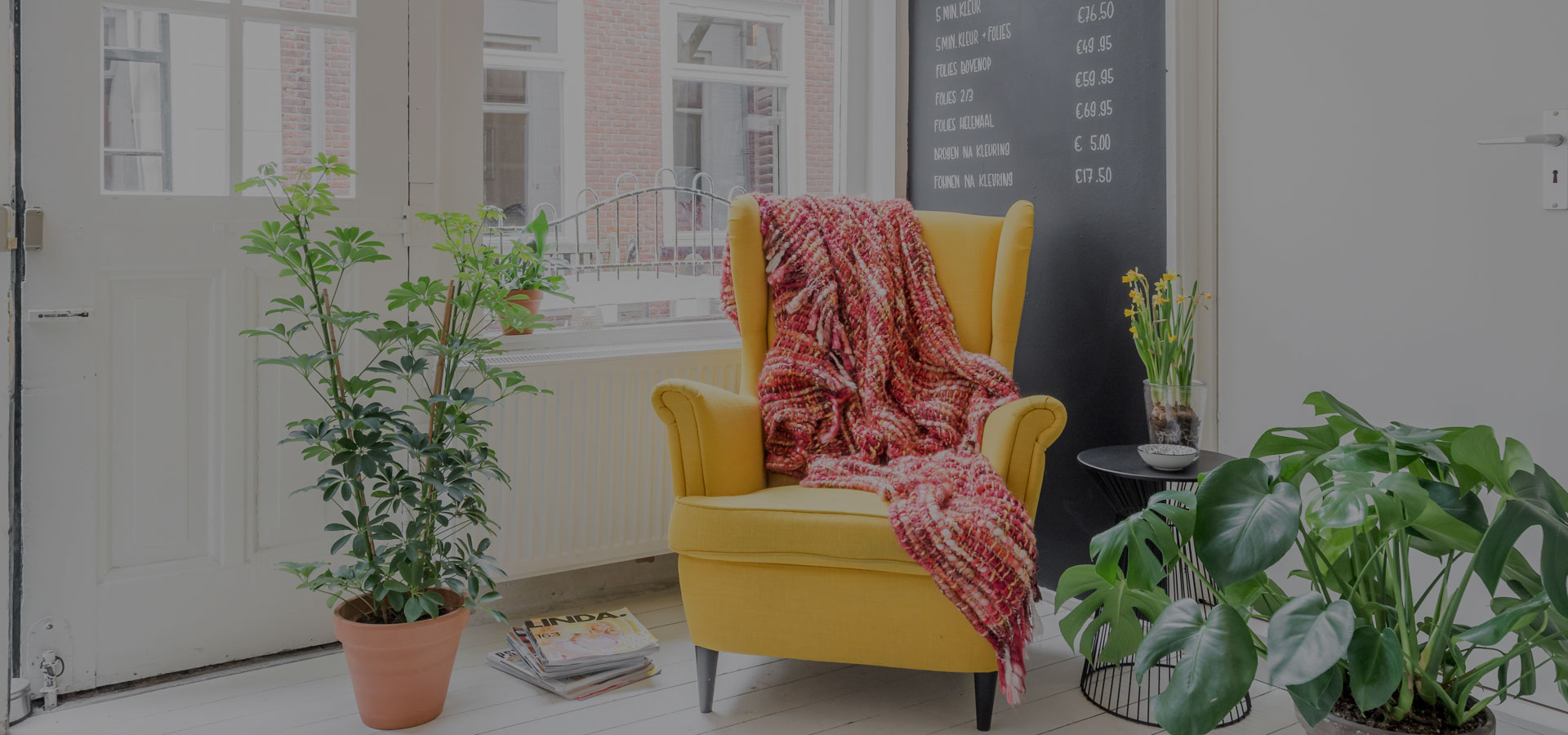 Deel van het interieur van Haaratelier Marjon! in Haarlem met comfortabele gele oorfauteuil.