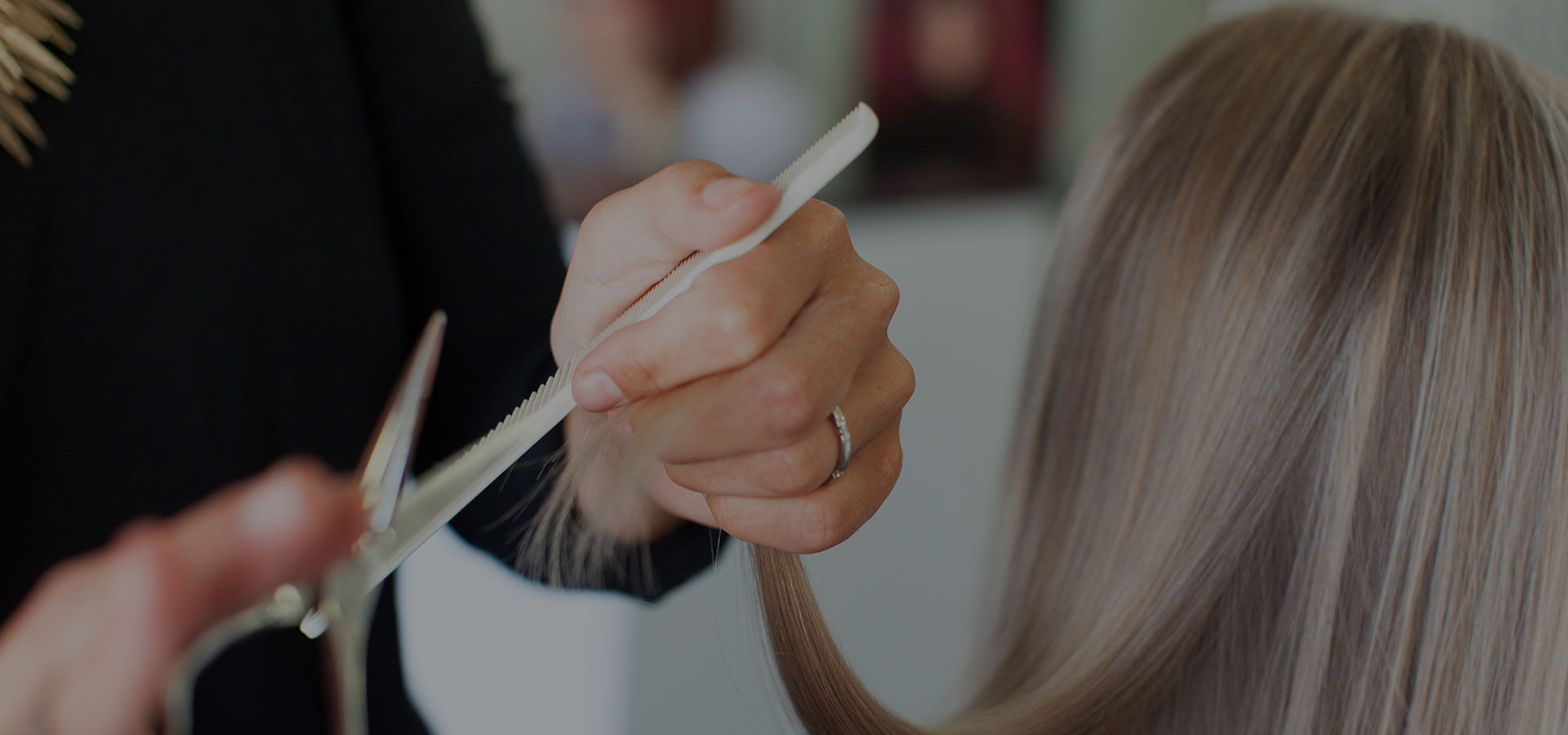 Vrouw laat haar natuurlijk grijs lang haar in verschillende tinten met highlights en lowlights bijpunten door de kapper.