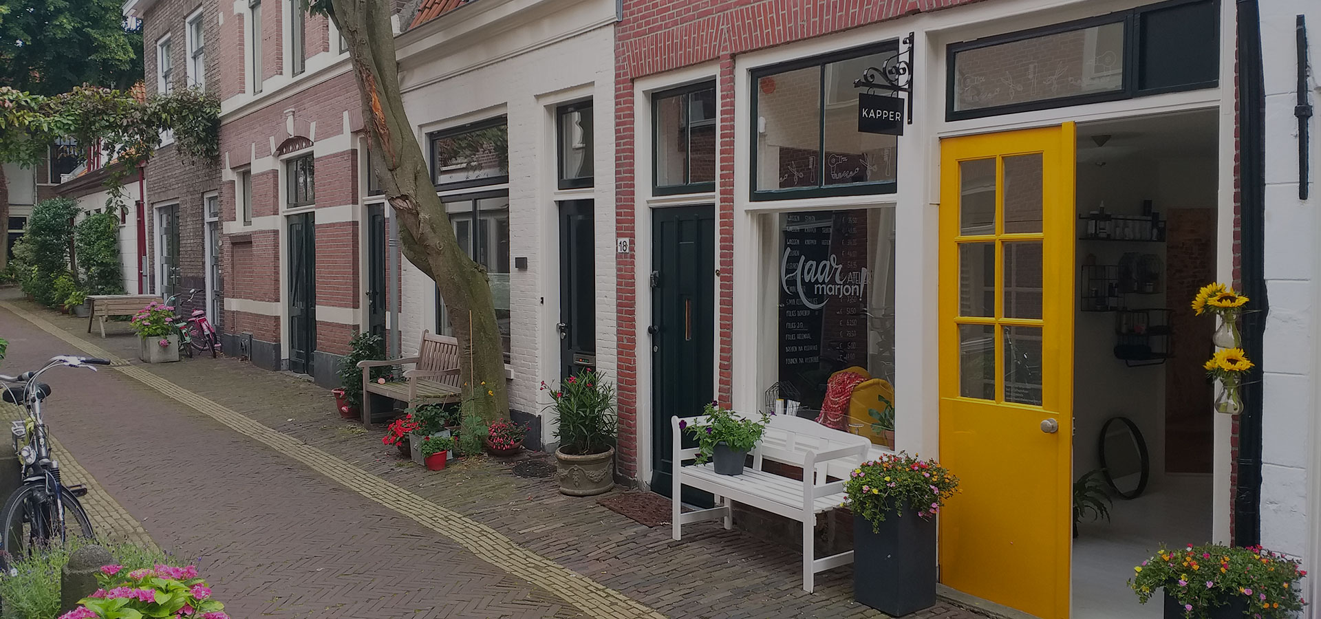 Kapsalon Haaratelier Marjon! in de Drapenierstraat 18 in Haarlem-Centrum met donkergele dubbele voordeur.